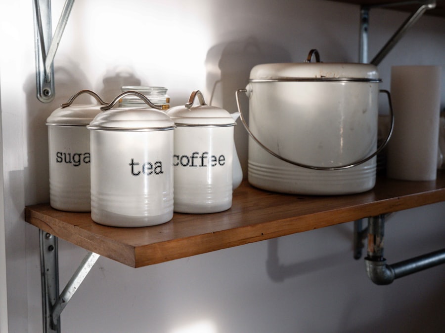 White enamel canisters lined up along a tidy kitchen shelf.