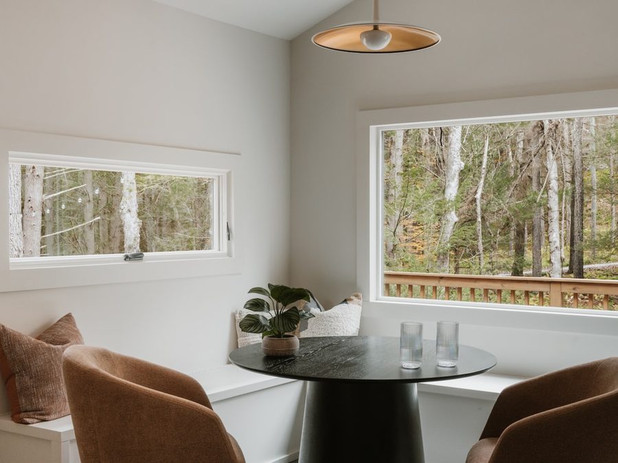 Two upholstered armchairs and a cushioned window seat in a bright cottage nook.