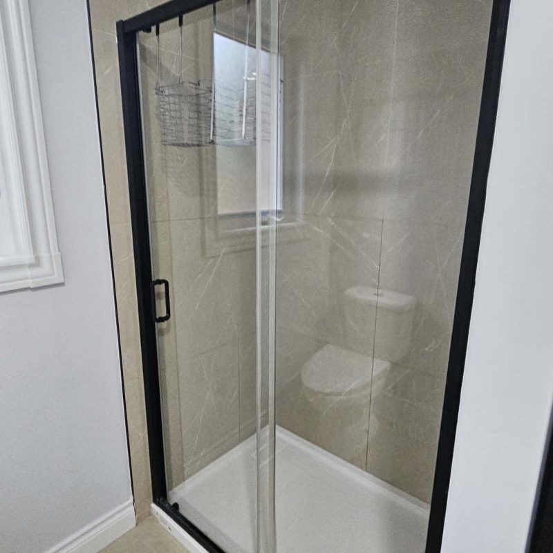 The same shower screen after cleaning, the glass clear enough to see straight through.